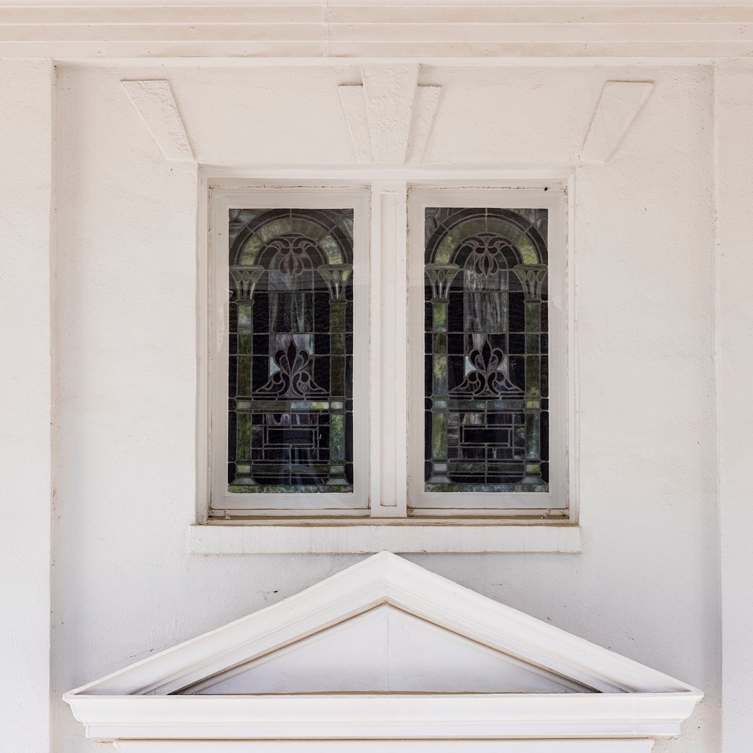 Second-floor windows and door pediment above the main entrance of First Methodist Church, Opelika, Alabama